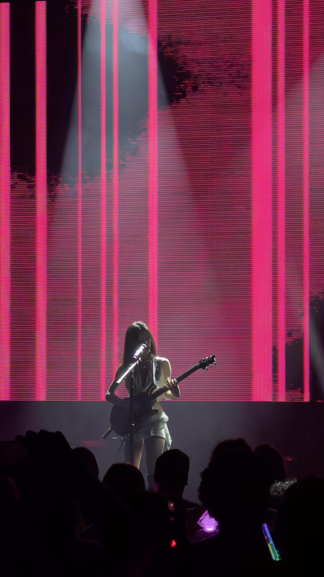 An ARTMS performance with a guitar under red stage lighting
